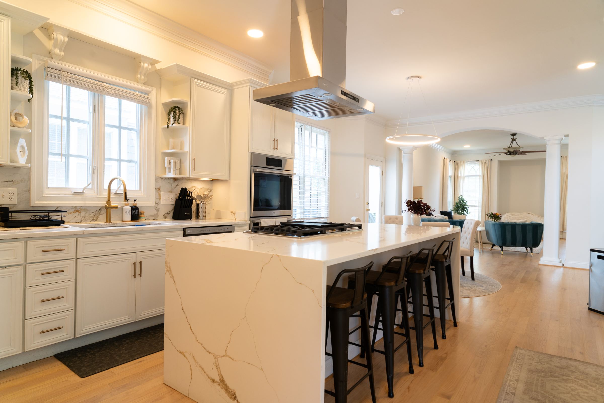 Renovated kitchen with quartz waterfall island and brass fixtures