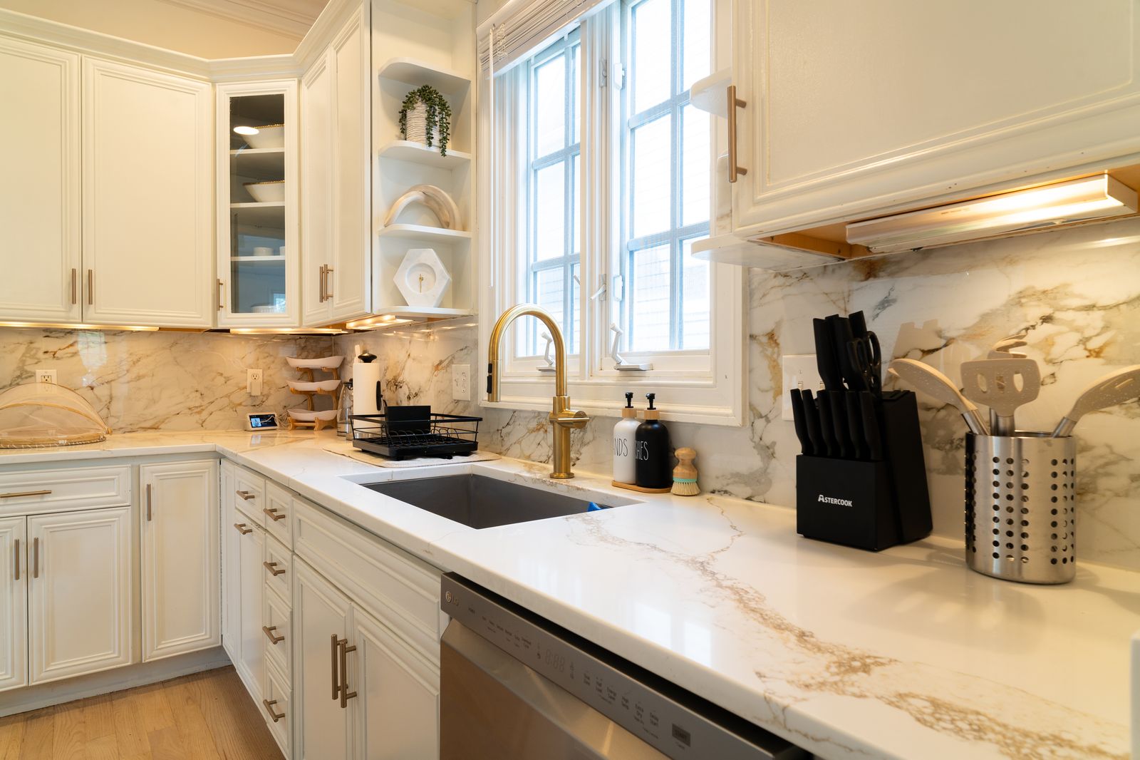 Quartz backsplash with brass gooseneck faucet